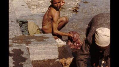 Nepal 1970s, Two man washing their clothes in pond during daytime