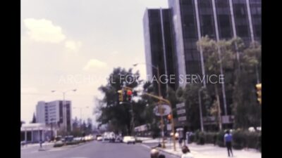 Mexico 1970s, City view with car parking and buildings from running car