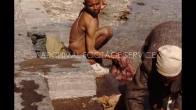 Nepal 1970s, Two man washing their clothes in pond during daytime