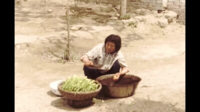 China 1980s, Woman cutting vegetable in outside
